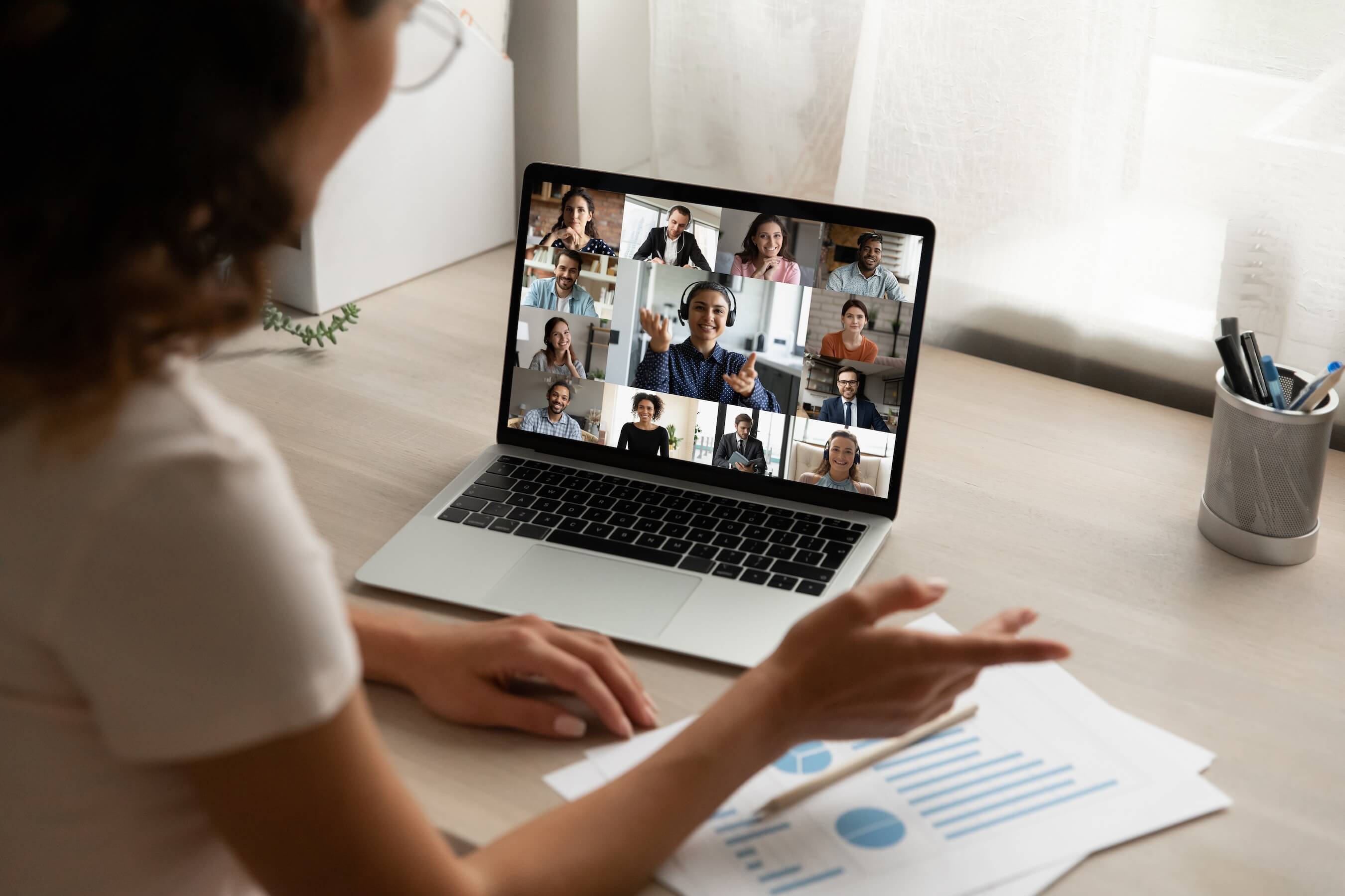 Eine Frau sitzt mit unterschiedlichen Menschen in einem Onlinemeeting.