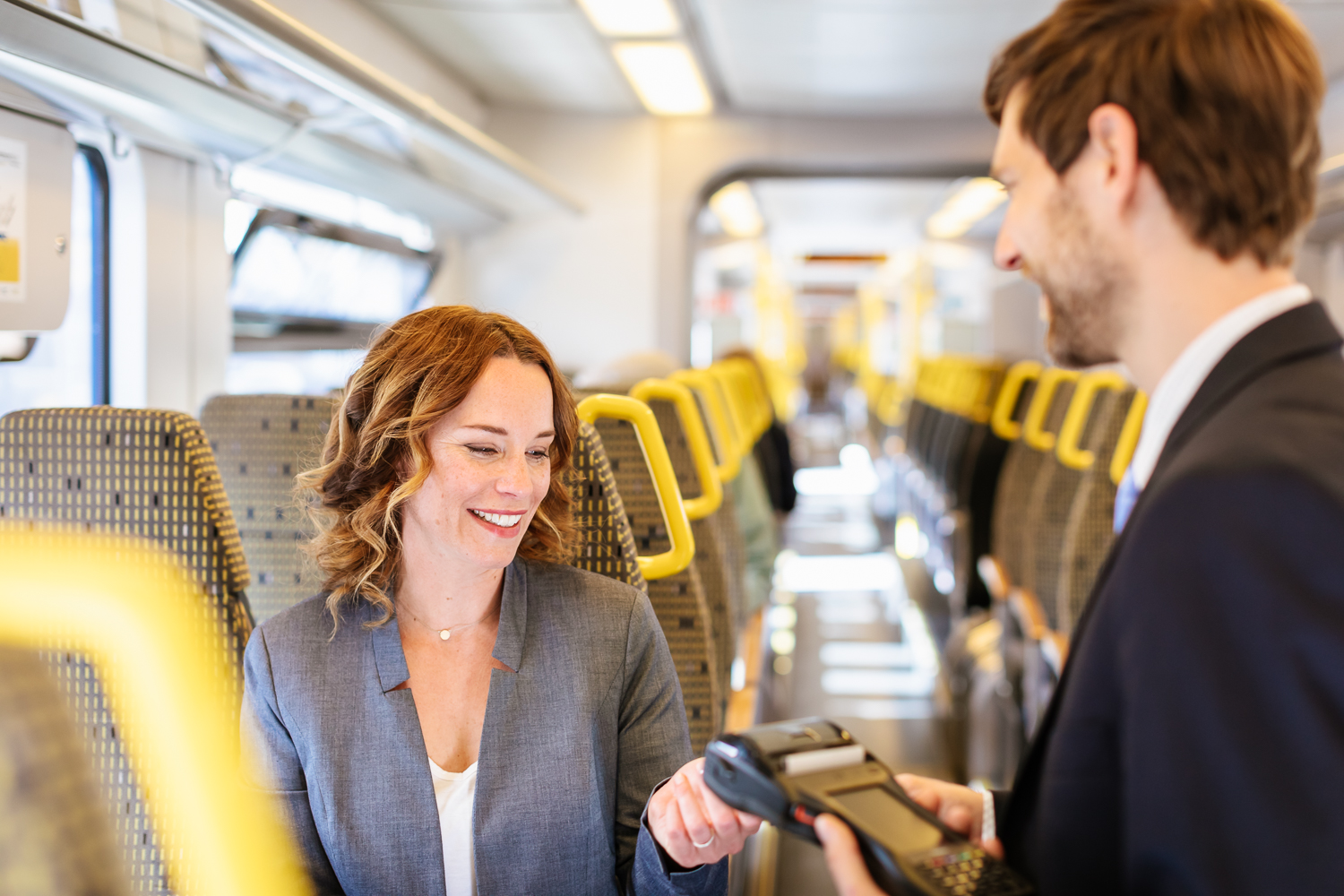 Ein Kundenbetreuer checkt das Ticket einer Frau.