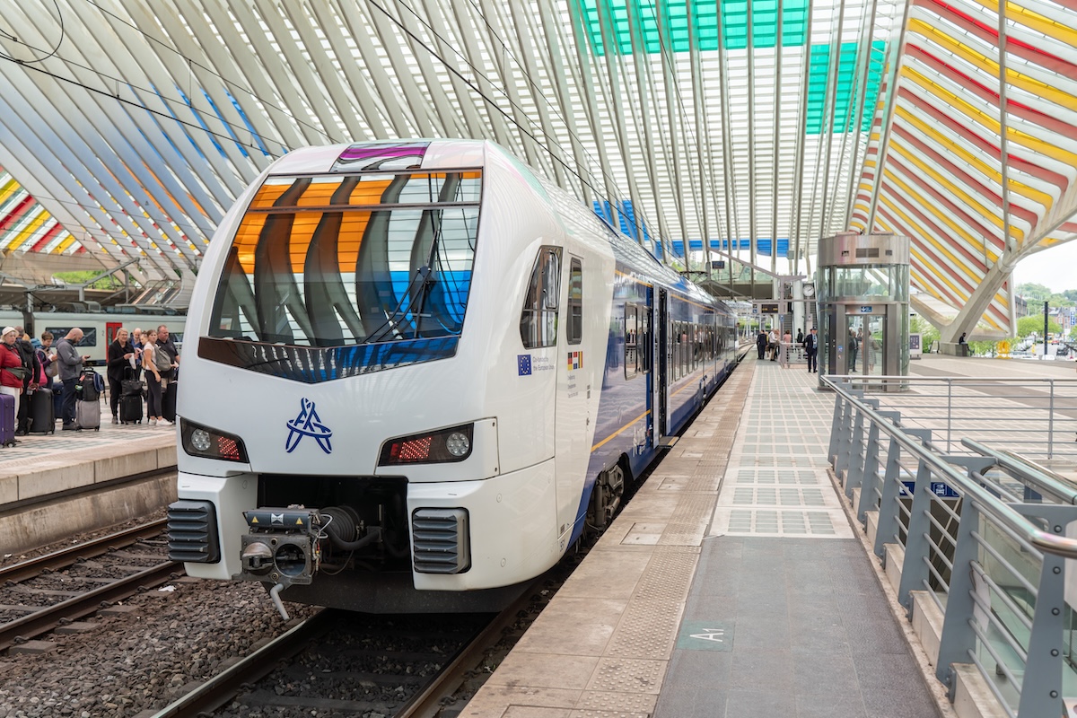 Ein Zug des Unternehmens Arriva steht an einem Bahnhof. 