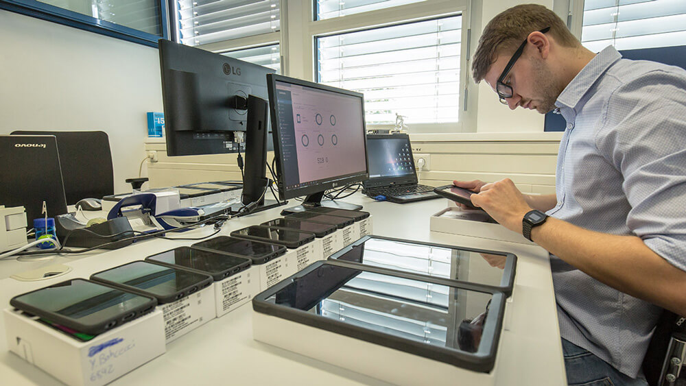 Ein Mitarbeiter sitzt vor einem Computer an einem Schreibtisch.