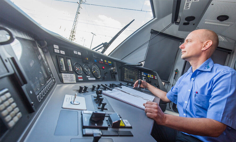 Aufnahme eines Triebfahrzeugführers im Cockpit, während er die Bahn mit den Steuermodulen führt. 