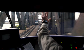 Ein Lokführer im Cockpit, der eine entgegenkommende Bahn grüßt.