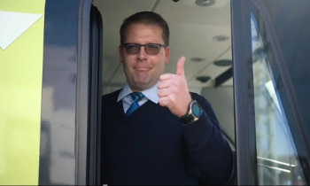 Ein Mann der seine Prüfung zum Lokführer bestanden hat und glücklich den Daumen nach oben zeigt.