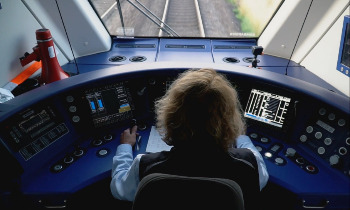 Lokführerin in einem Cockpit einer Bahn. 