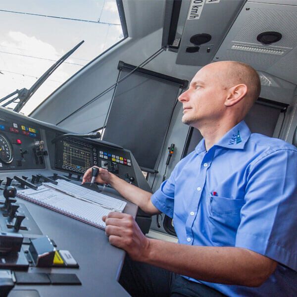 Aufnahme eines Triebfahrzeugführers im Cockpit, während er die Bahn mit den Steuermodulen führt. 