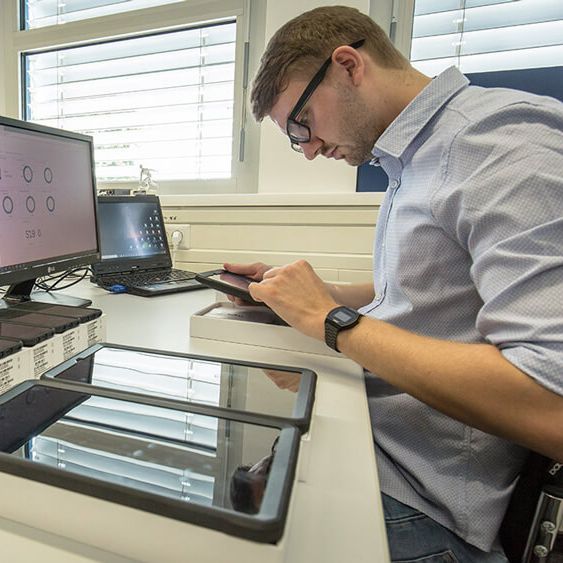 Ein Mitarbeiter sitzt vor einem Computer an einem Schreibtisch.