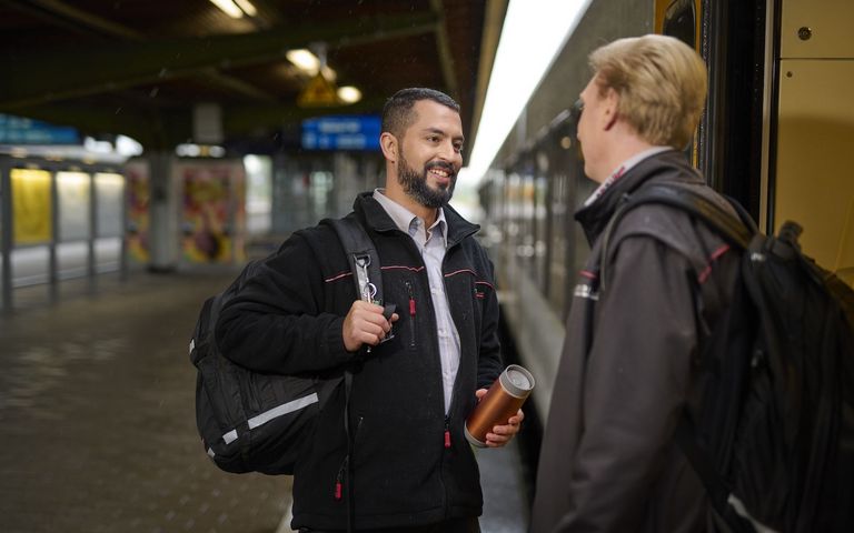 Zwei Triebfahrzeugführer begrüßen sich bei ihrem Schichtwechsel. 