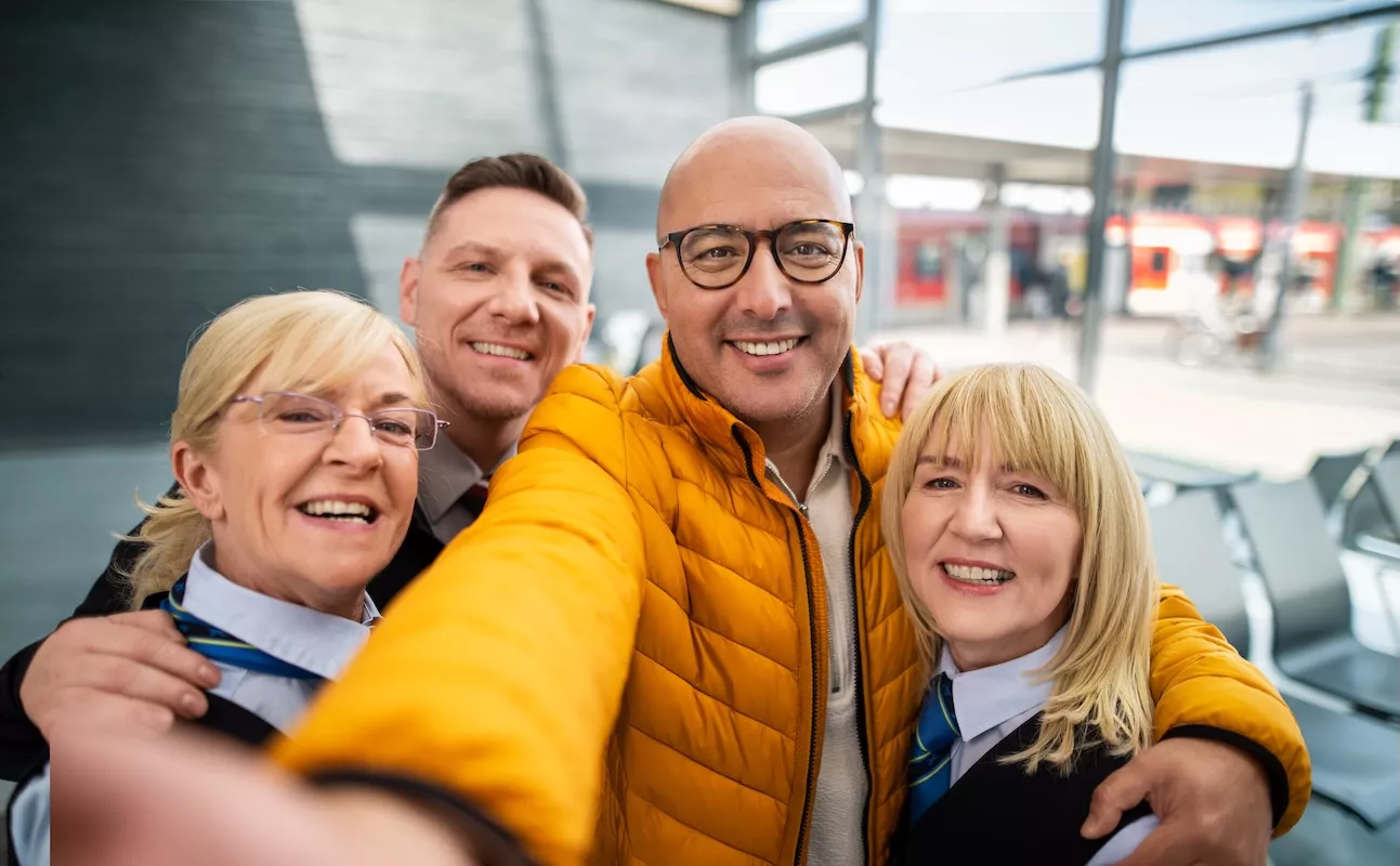 Eine Gruppe von Bahner*innen posiert für die Kamera an einem Bahnhof