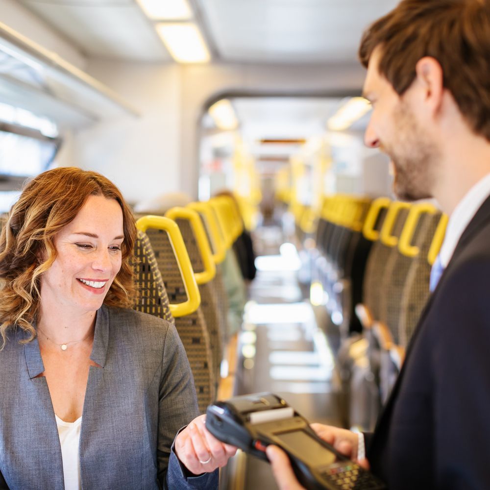 Ein Kundenbetreuer checkt das Ticket einer Frau.