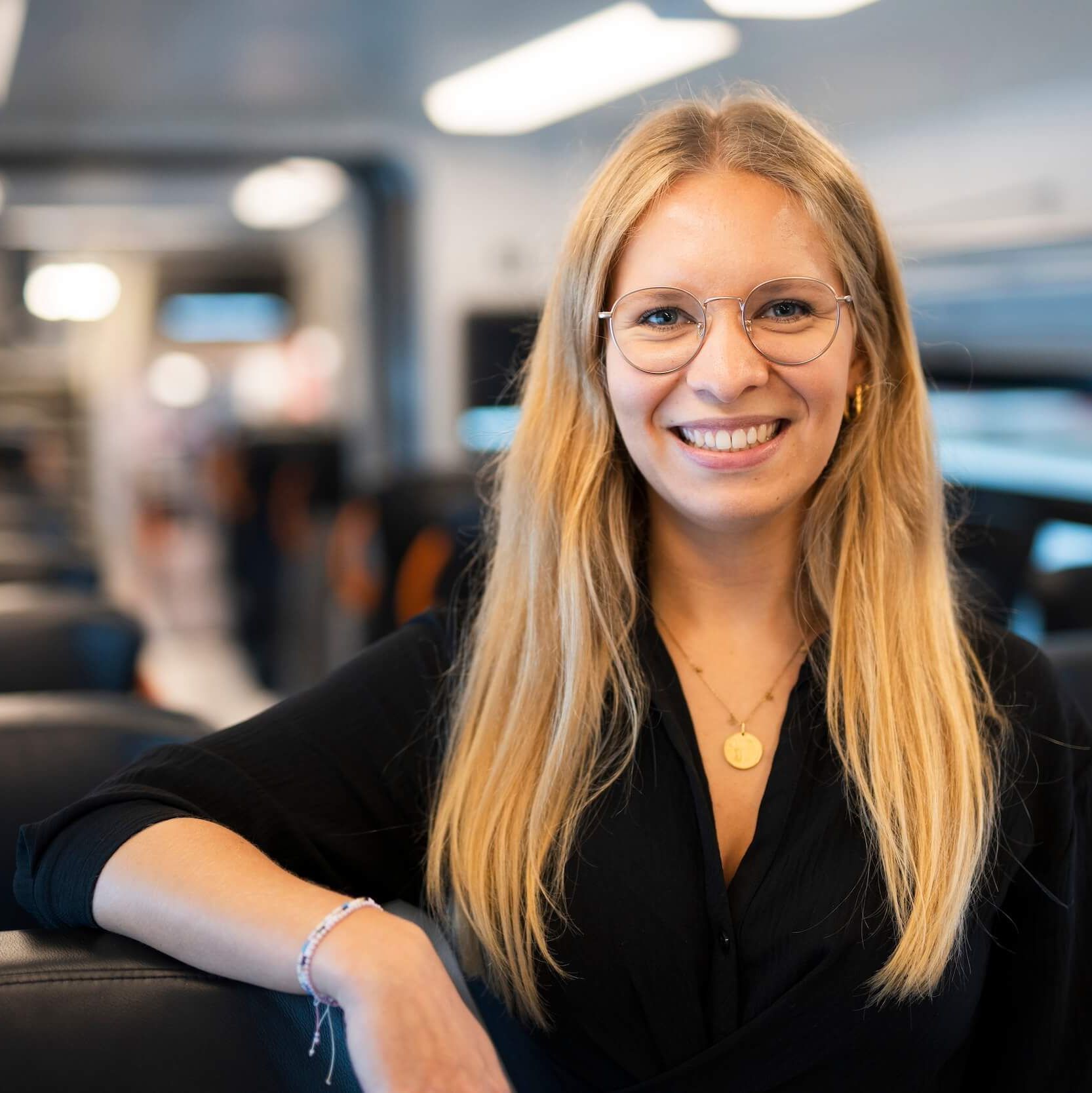 Eine lächelnde Frau steht in der Bahn.