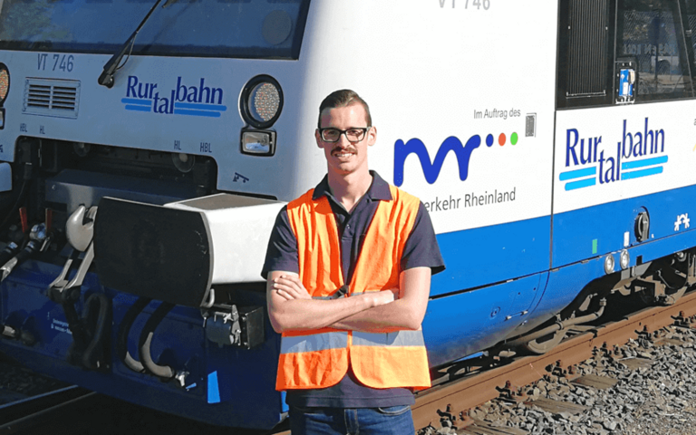 Marco Bronner steht vor einem Zug der Rurtalbahn