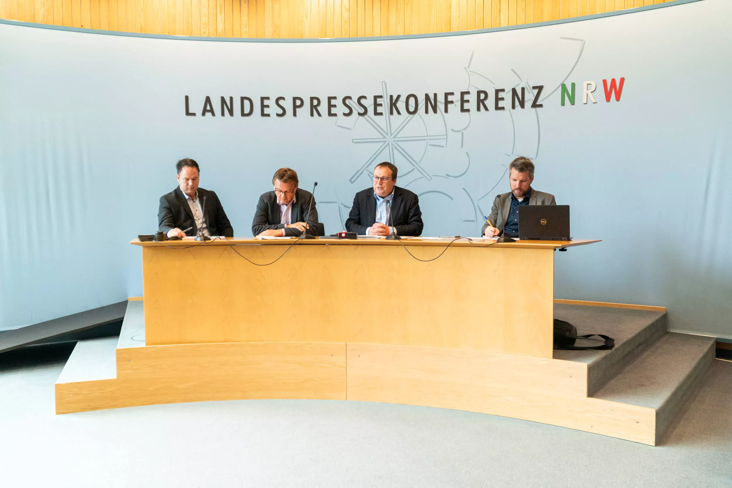 Umwelt- und Verkehrsminister Oliver Krischer und die Programmleiter von Fokus Bahn NRW sitzen auf einem Podium.