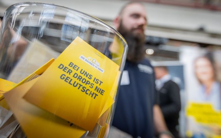 Werbematerial liegt auf einer Jobmesse für die Besuchenden in einer Glasschüssel.