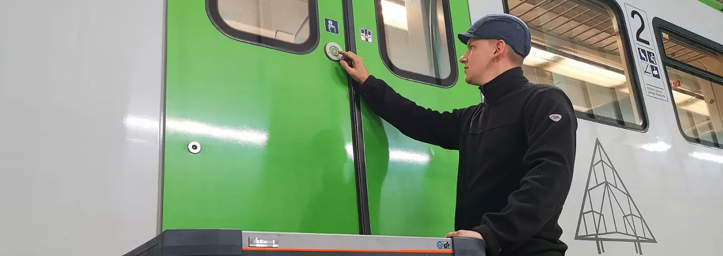 Ein Mitarbeiter prüft eine Tür an einem grünen S-Bahn-Wagen