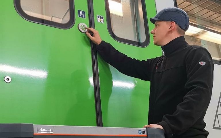 Ein Mitarbeiter prüft eine Tür an einem grünen S-Bahn-Wagen