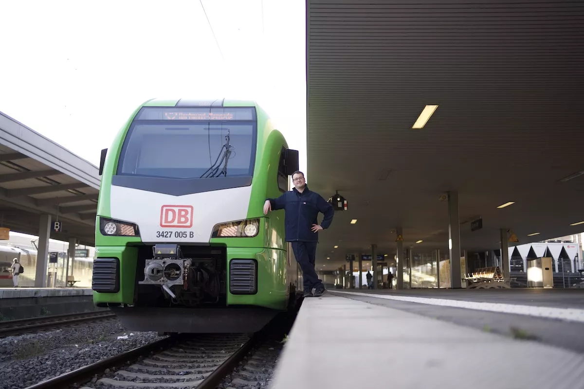 Ein Triebfahrzeugführer steht neben seiner Bahn am Essener Hauptbahnhof.